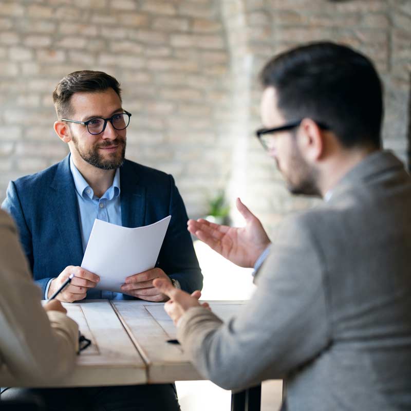 two men talking at conference table
