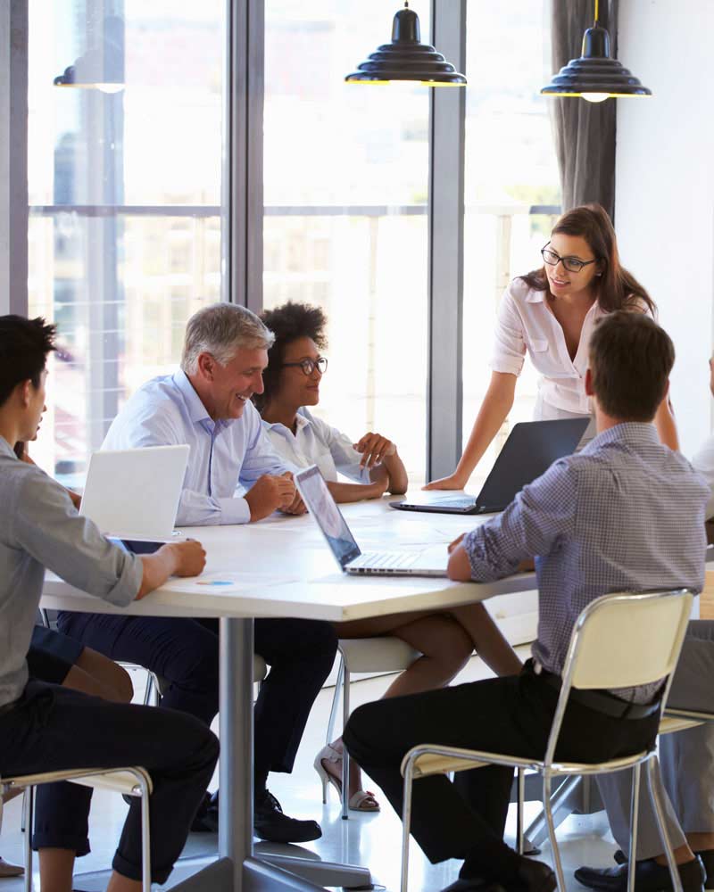 women leading diverse team meeting in conference room